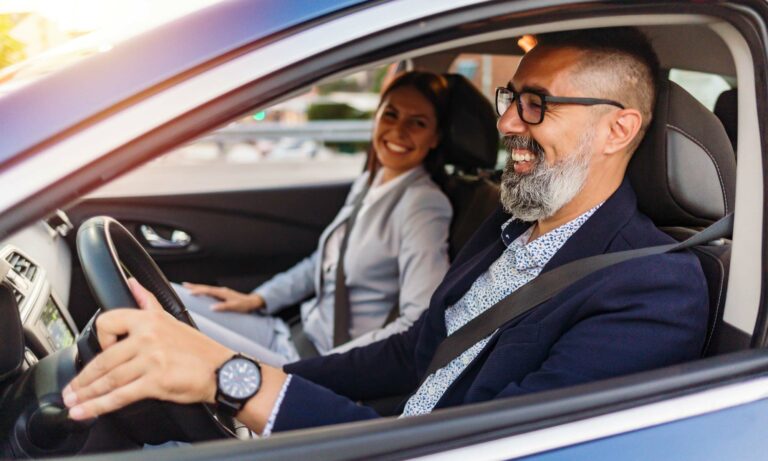 A man and a women in a car wearing glasses.