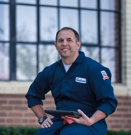 Auto Expert Andrew Giorgi dressed in his mechanic coveralls with a tablet in his hand