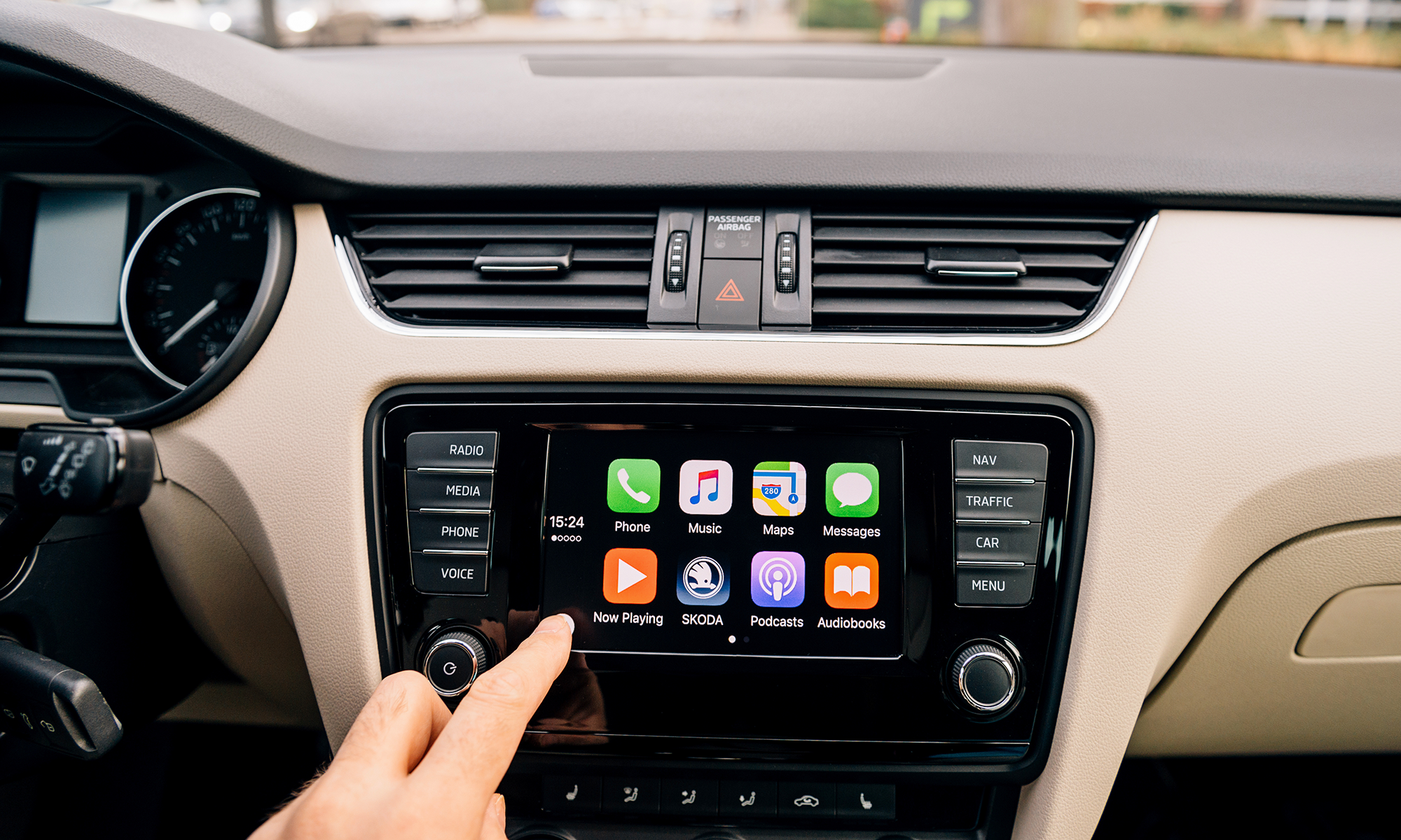 Primer plano de la mano de una persona seleccionando una aplicación en la pantalla de infoentretenimiento de su coche. Próximamente, los fabricantes podrían empezar a cobrar cuotas de suscripción a los propietarios para usar funciones como esta y otras, como asientos calefactables y más.
