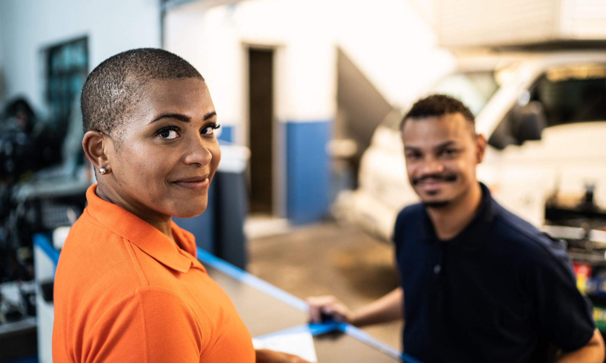 Un cliente y una vendedora en un taller de reparación de automóviles.