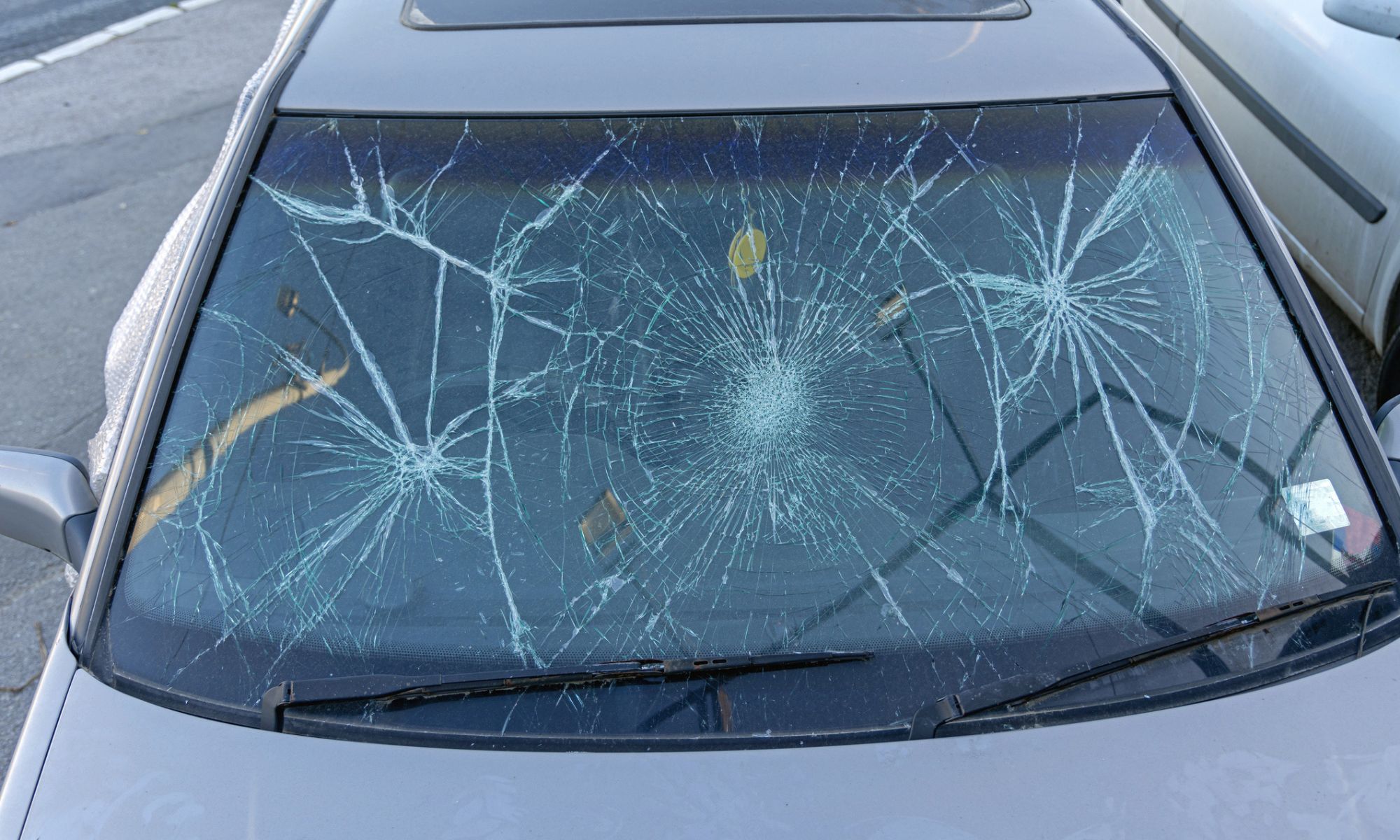 Parabrisas roto en un automóvil por daños causados por granizo y tormentas