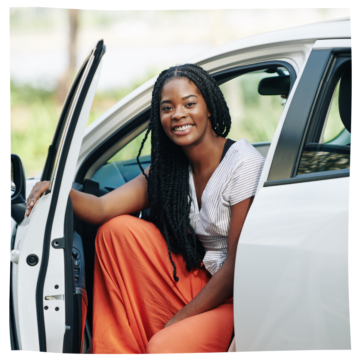 Woman smiling and sitting in her Honda car