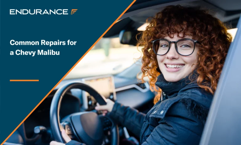 Red headed woman smiling while in the drivers seat of her car