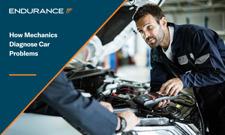 Auto mechanics talking while working with car diagnostic tool