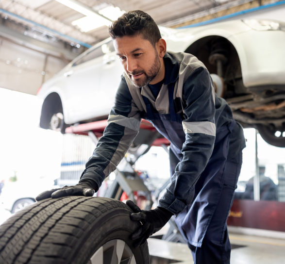 Man in repair shop rolling tire