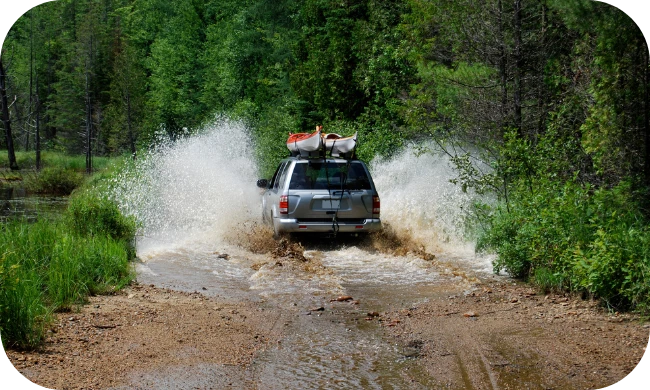 Vehículo Subaru circulando por un charco de barro