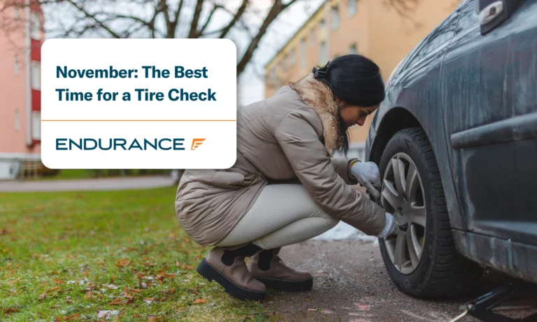 Young woman preparing for winter by changing to winter tires on her car