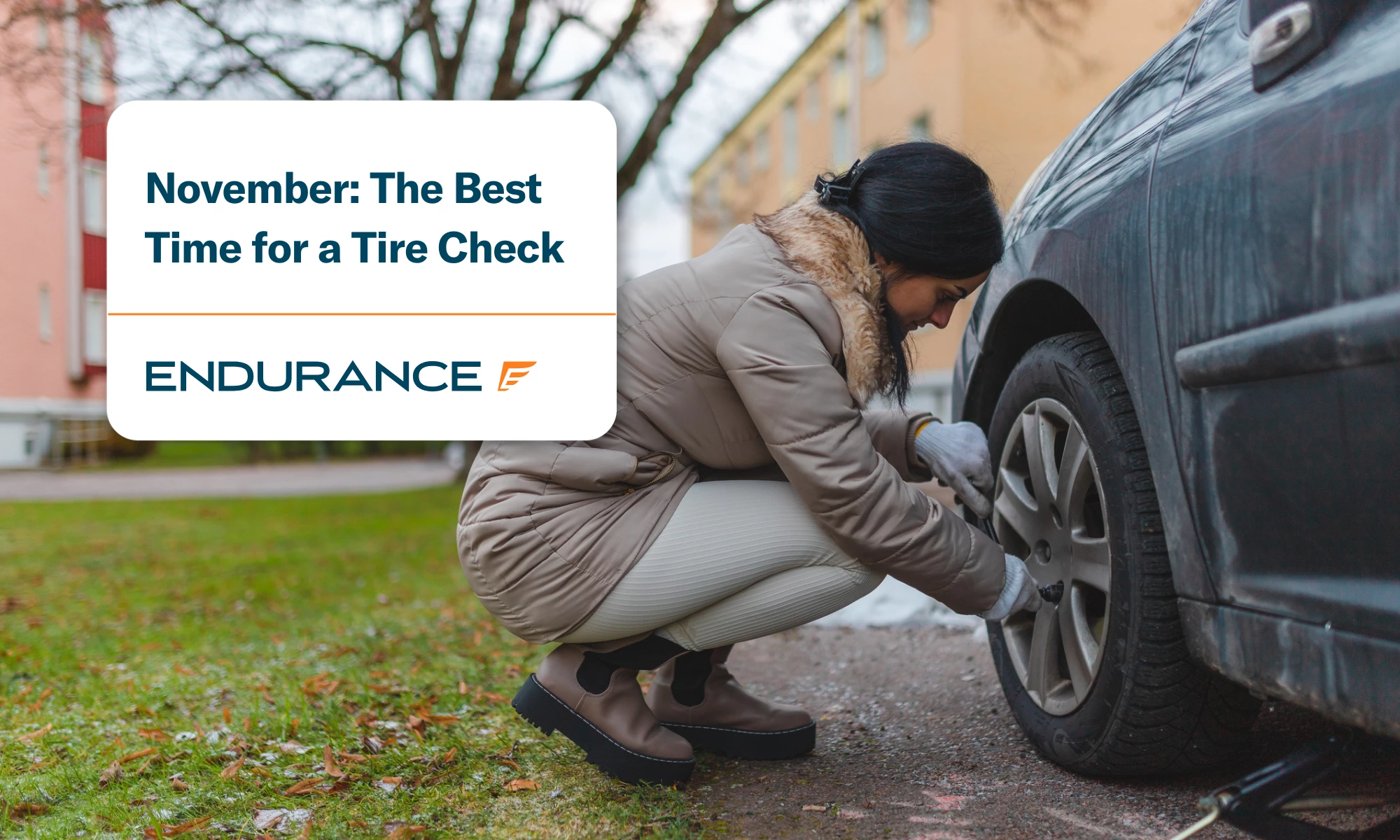 Young woman preparing for winter by changing to winter tires on her car