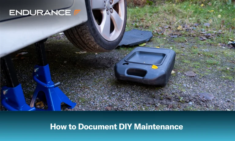 A car raised and ready for an oil change, with an oil drain pan nearby