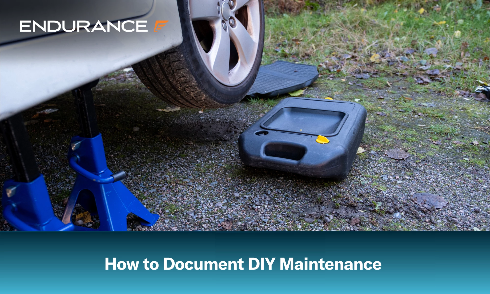 A car raised and ready for an oil change, with an oil drain pan nearby