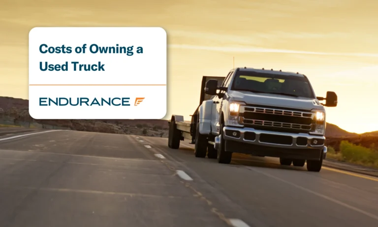 A white truck driving down the interstate, the costs of owning a used truck