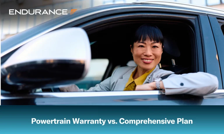 Smiling woman in drivers side of car, powertrain warranty vs comprehensive plans