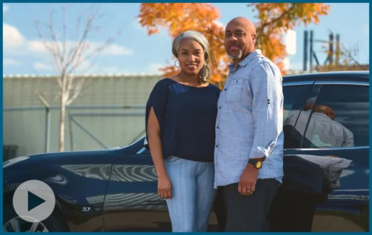 Shon and Latress Standing In Front of Their Vehicle Smiling