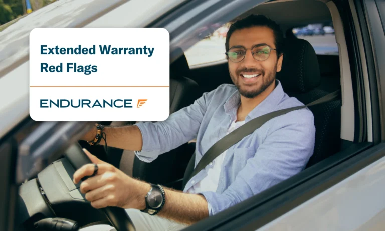 Smiling man driving a car, extended warranty red flags to look out for
